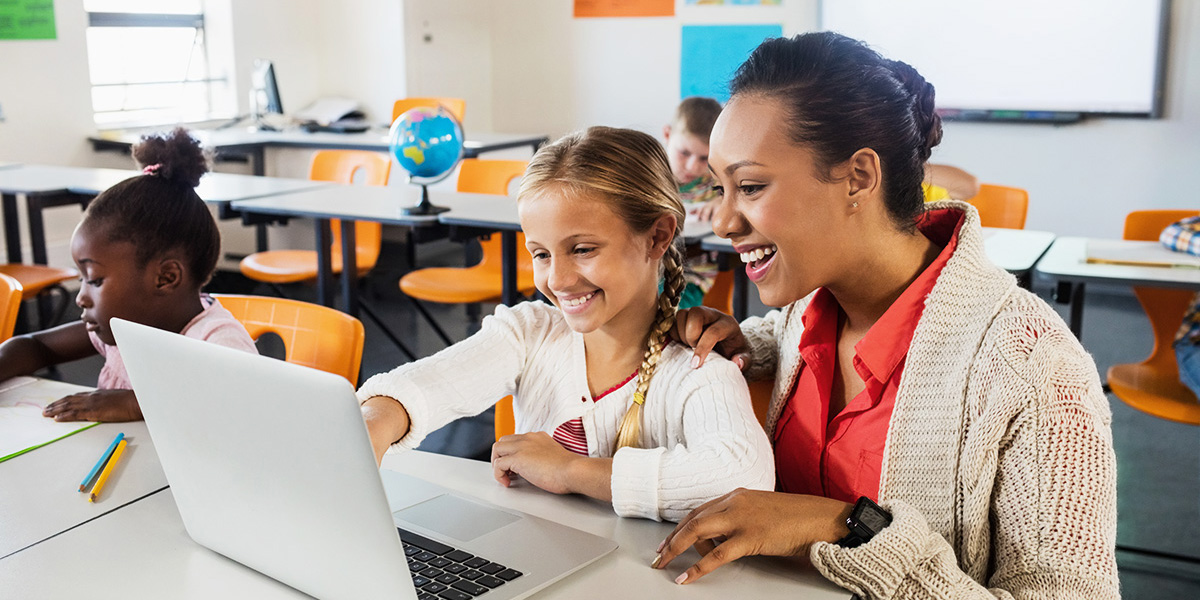 teacher with student at computer